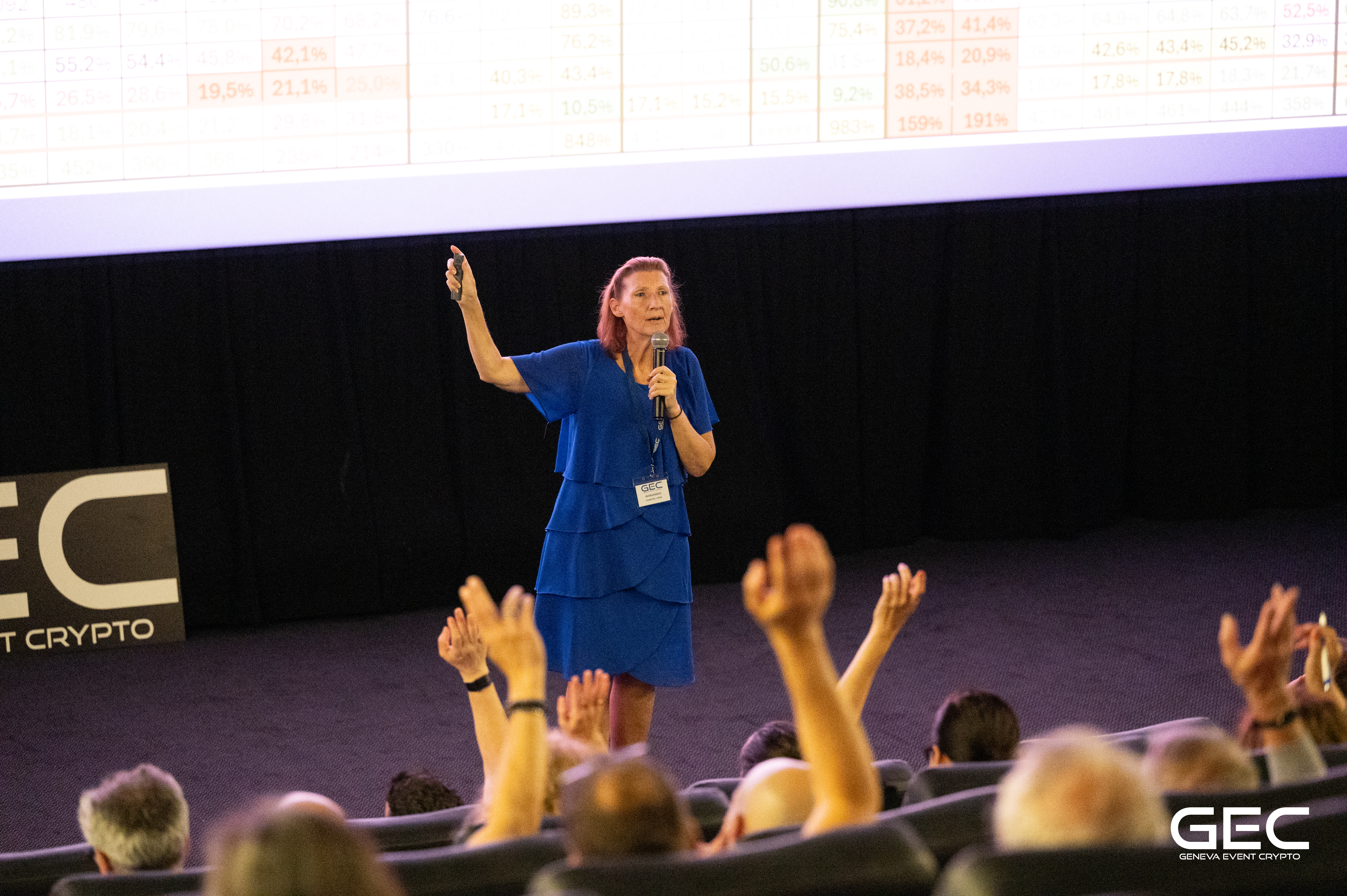 Chantal Läng speaking at GEC Geneva Event Crypto 2024 — full auditorium with hands raised